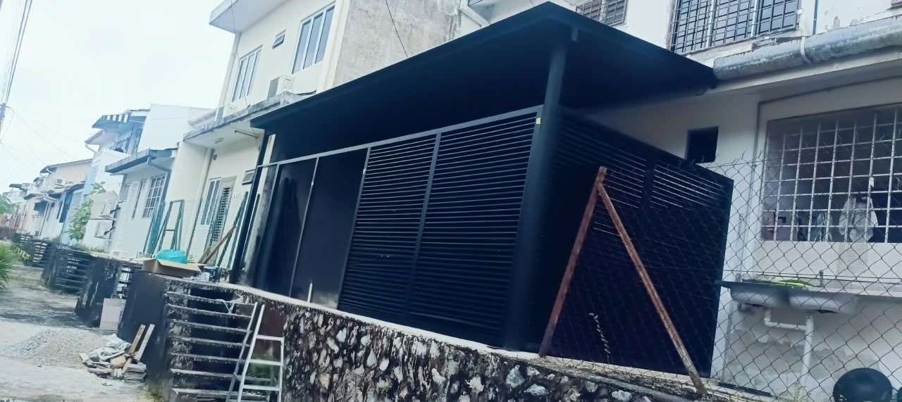 Selepas: awning siap dengan bumbung dan panel louvre hitam di hadapan rumah teres